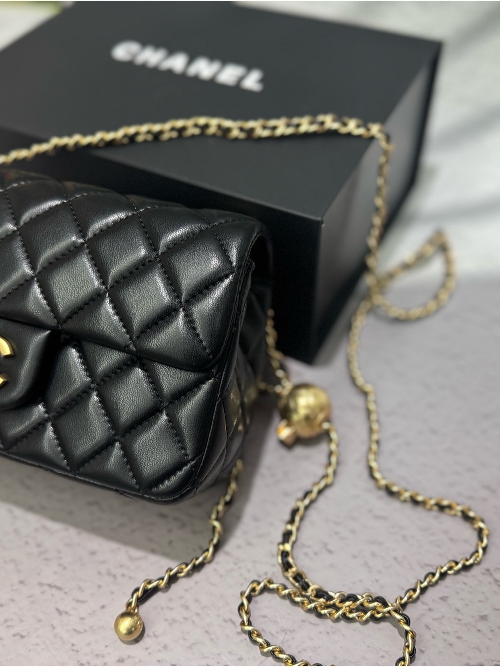 CHANEL. Black Quilted Lambskin Mini Crossbody with Gold Chain